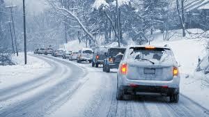 Cars driving safely on a snowy road during winter weather conditions in the London