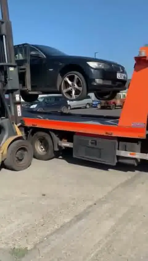 Black Car being loaded onto a flatbed tow truck by WhiteRecovery vehicle recovery service in London