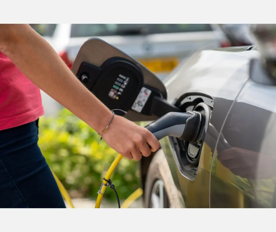 Person charging an electric car in London before EV towing or roadside assistance