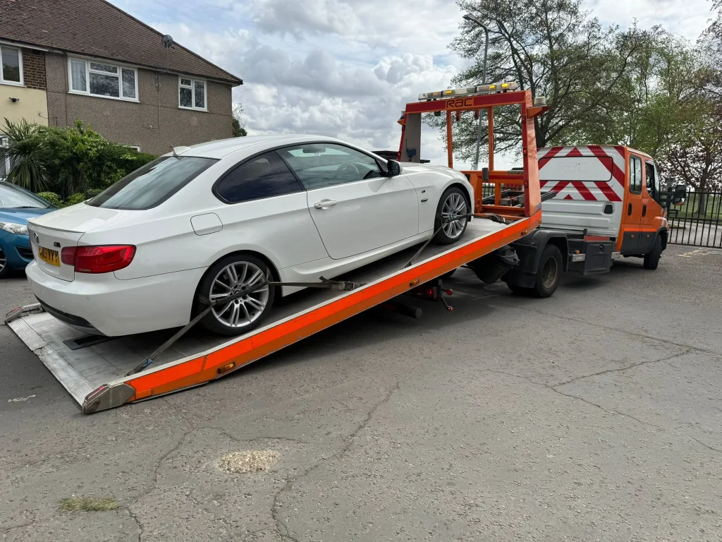 White BMW 3 Series being towed by WhiteRecovery recovery truck in Romford.