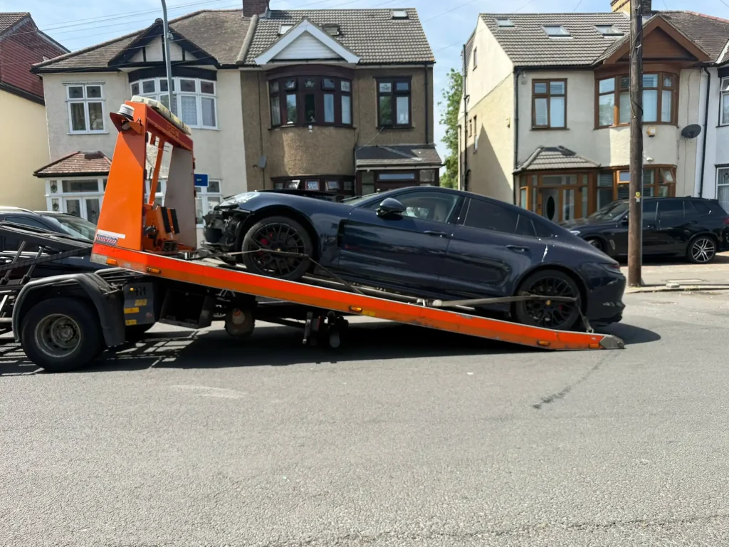 24-hour car and van recovery service in Upminster London by White Recovery transporting a black accidented car on a recovery truck