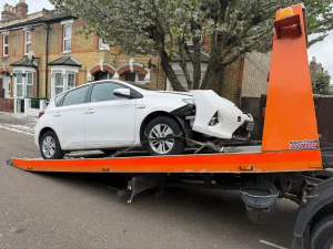 White Recovery | Car Recovery Service in London – Breakdown Recovery | White Recovery Damaged white hatchback loaded onto a recovery truck by White Recovery in Romford following a road traffic accident.