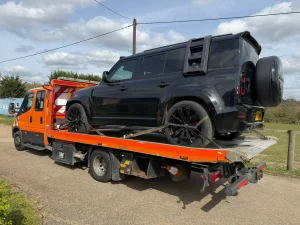 White Recovery | Car Recovery Service in London – Breakdown Recovery | White Recovery Black Land Rover Defender secured on a recovery truck by White Recovery in Hornchurch for 24-hour vehicle recovery and transport.