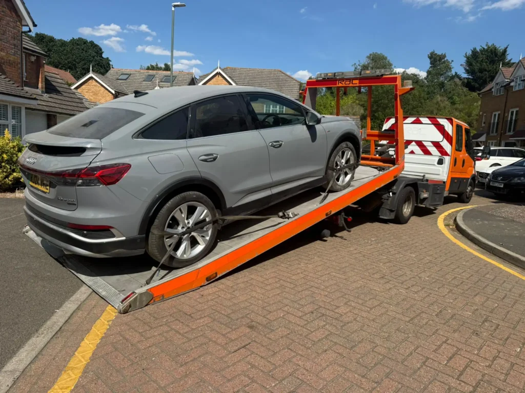 Grey Audi SUV secured on a White Recovery flatbed tow truck providing professional car recovery service in Gidea Park, London.