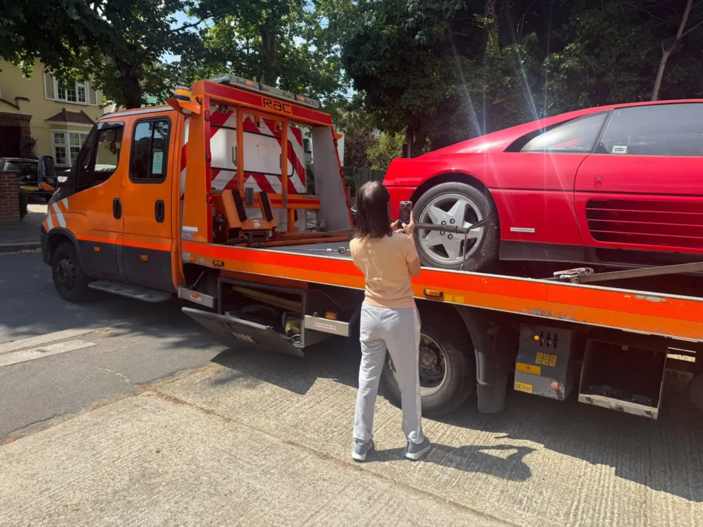 White Recovery tow truck loading a red sports car for professional car recovery service in Gidea Park, London.