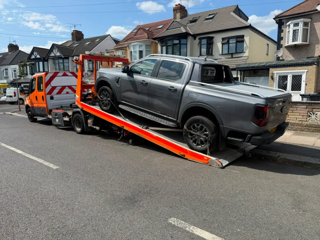 Pickup truck being recovered on a flatbed recovery vehicle