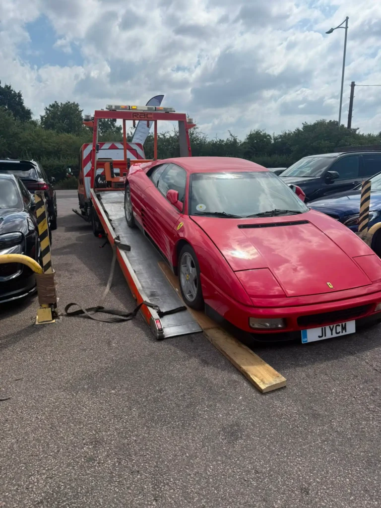 Red Ferrari being transported on a car recovery truck in Chelsea