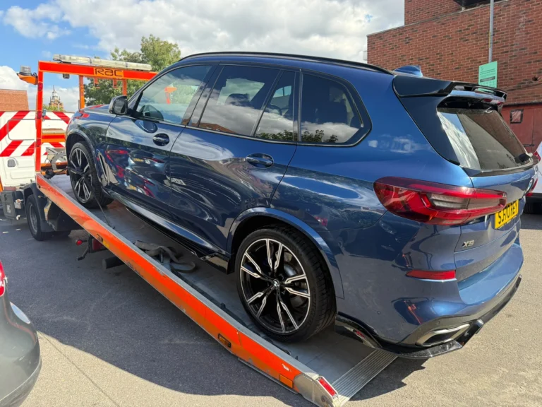 Blue BMW X5 loaded onto a flatbed recovery truck for car recovery in Southend.
