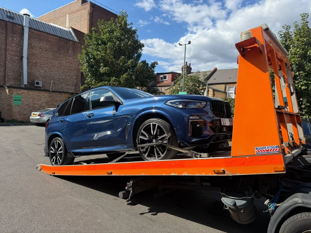 Blue sports coupe secured on a flatbed recovery truck for car recovery in Southend.