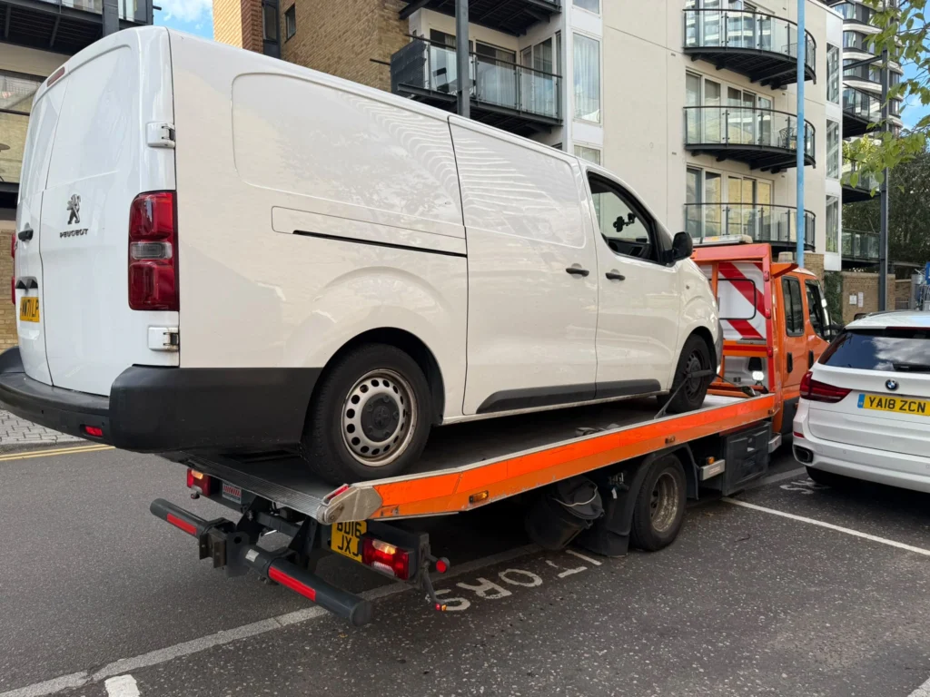 White van loaded onto a flatbed tow truck for van recovery in Southend.